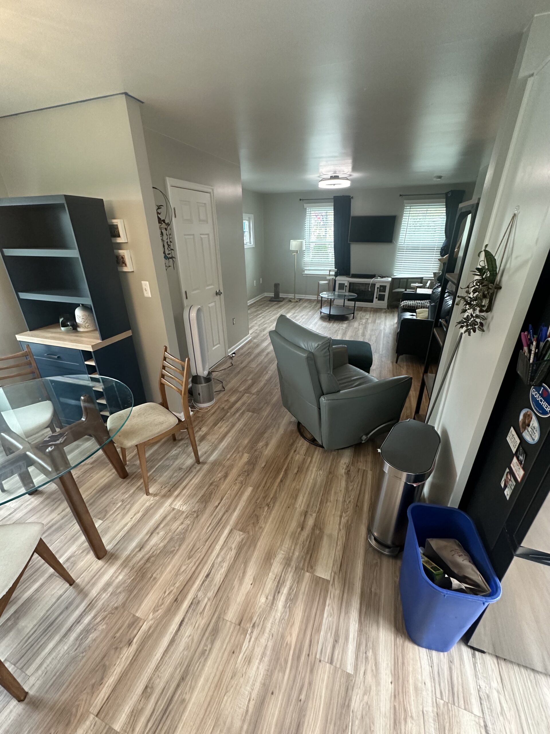 Living room with new light wood vinyl plank flooring installed, showcasing modern and clean interior after renovation.